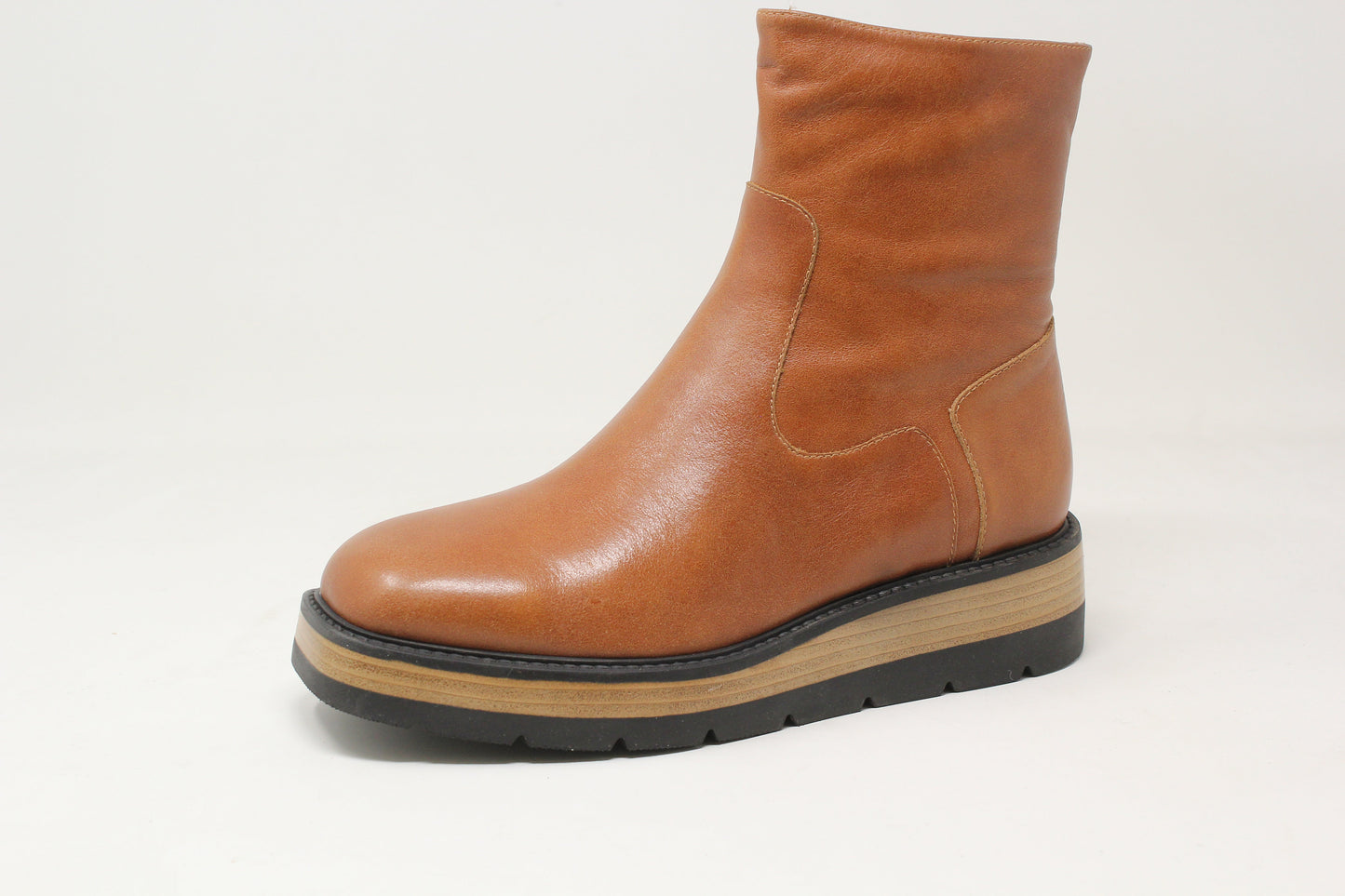 Brown leather boot with a thick sole on a light gray background