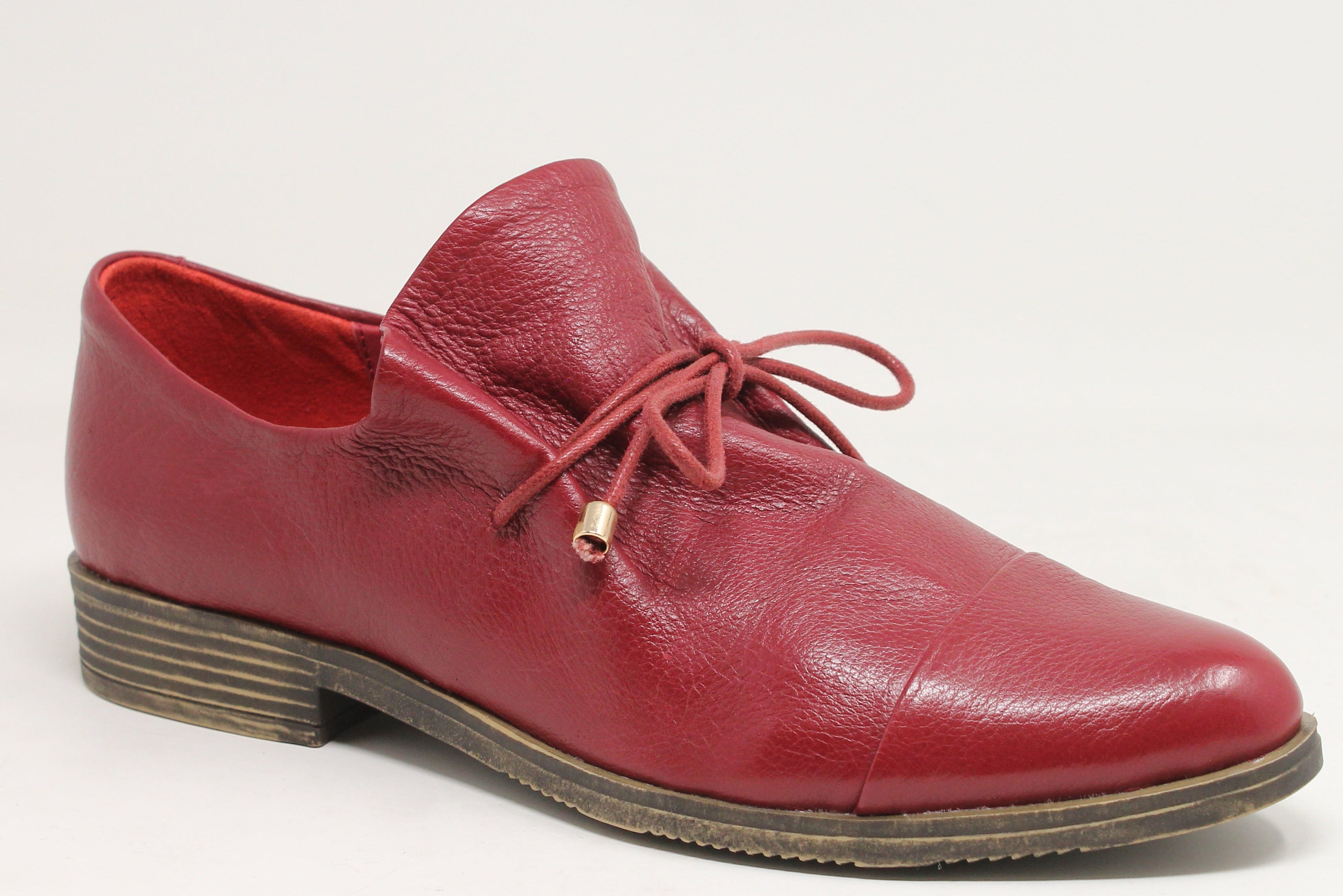 Red leather shoe on a light gray background